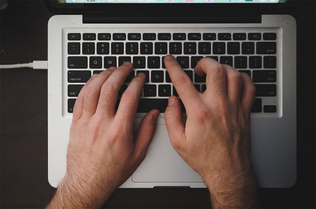 A man types a proposal on his computer